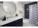 Clean bathroom with navy vanity, marble countertop, and blue patterned shower curtain at 343 Elati St, Denver, CO 80223