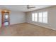 Spacious living room with neutral carpet and plantation shutters at 41321 E 88Th Ave, Bennett, CO 80102
