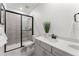 Modern bathroom with a walk-in shower, gray tile, and white vanity at 16655 W 93Rd Pl, Arvada, CO 80007