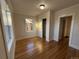 Bright bedroom with hardwood floors, a large window, and access to a hallway at 1674 S Lincoln St, Denver, CO 80210