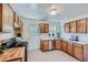 Functional kitchen with wood cabinets, stainless steel appliances, and a door leading to the backyard at 2854 Eliot St, Denver, CO 80211
