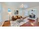 Bright living room with hardwood floors, featuring a comfortable couch and a view into the dining area at 2854 Eliot St, Denver, CO 80211