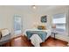 Cozy bedroom with hardwood floors, featuring a bed, a bench, and access to a private deck at 2854 Eliot St, Denver, CO 80211
