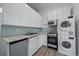 Modern kitchen with white cabinets and stacked Bosch washer and dryer at 2524 Kensing Ct, Denver, CO 80211