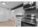 Modern kitchen features stainless steel appliances and gray hexagonal tile backsplash at 203 Wright St # 208, Lakewood, CO 80228