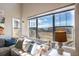 Living room view showcasing large windows with neighborhood views and comfortable seating at 664 Fossil Bed Cir, Erie, CO 80516