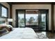 Bright bedroom with a plush bed and sliding glass doors to a deck at 7474 Spring Drive, Boulder, CO 80303