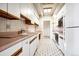 Bright kitchen features white cabinetry and appliances, and pinkish countertops at 7877 E Mississippi Ave # 1102, Denver, CO 80247