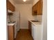 Neat kitchen with light wood cabinets, white appliances, and wood-look flooring at 912 S Peoria St, Aurora, CO 80012