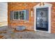 Front entrance of a brick home with a security door and window at 13969 E Utah Cir, Aurora, CO 80012