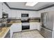 Updated kitchen, featuring stainless steel appliances and tile flooring at 13969 E Utah Cir, Aurora, CO 80012