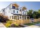 Two-story modern home with light-colored siding, wood accents, and a fenced yard at 1411 Zenobia St, Denver, CO 80204