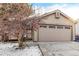 Tan house exterior with a two-car garage and snow-covered front yard at 11532 E 1St Ave, Aurora, CO 80010