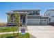 Two-story house with gray siding, a three-car garage, and a landscaped front yard at 3352 N Highlands Creek Pkwy, Aurora, CO 80019