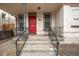 Welcoming front porch with red door and wrought iron railings at 1516 Lafayette St, Denver, CO 80218
