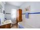 Bathroom with white tile, tub, and wooden vanity at 6597 S State Highway 83, Franktown, CO 80116