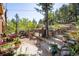 Rustic backyard with stone retaining walls, stairs, and potted plants at 80 Outlook Dr, Golden, CO 80403