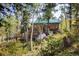 Wooden cabin nestled in trees, surrounded by lush greenery at 80 Outlook Dr, Golden, CO 80403