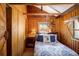 Cozy bedroom with wood-paneled walls and a comfortable bed at 80 Outlook Dr, Golden, CO 80403