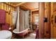 Bathroom with clawfoot tub, shower, and wood-paneled walls at 80 Outlook Dr, Golden, CO 80403