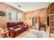 Living room with wood-paneled walls, a recliner, and a wooden cabinet at 2718 S Victor St, Aurora, CO 80014