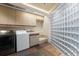 Functional laundry room with washer, dryer, and glass block wall at 30786 Snowbird Ln, Evergreen, CO 80439