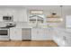 White kitchen with stainless steel appliances and quartz countertops at 3955 S Uinta St, Denver, CO 80237