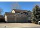 Two-story home with a three car garage and tree at 13031 Dexter St, Thornton, CO 80241