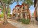 Victorian-style home with stone exterior, arched entryways, and mature trees at 3611-3615 Osage St, Denver, CO 80211