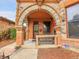 Front porch with stone archway, ornate iron railing, and a charming entryway at 3611-3615 Osage St, Denver, CO 80211