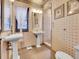 Classic bathroom with pedestal sinks, tiled shower, and decorative wallpaper at 3611-3615 Osage St, Denver, CO 80211