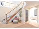 Bright entryway with curved staircase and sitting area at 6183 Buffalo Run, Littleton, CO 80125