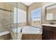 Bathroom featuring a corner bathtub and a glass-enclosed shower at 59304 E Commanche Way, Strasburg, CO 80136