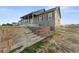 Gray siding home with a covered porch and stone retaining wall at 59304 E Commanche Way, Strasburg, CO 80136