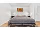 A simple bedroom with a bed, nightstands, and colorful artwork on the wall at 1700 Bassett St # 1319, Denver, CO 80202