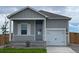 Simple ranch home with gray siding and a two-car garage at 2460 Christina St, Fort Lupton, CO 80621