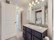 Bathroom with granite countertop, dark brown vanity, and stackable washer/dryer at 4100 Albion St # 512, Denver, CO 80216