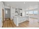 Open concept kitchen with white cabinets, center island, and stainless steel appliances at 3391 N Buchanan Way, Aurora, CO 80019