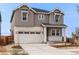 Two-story house with light brown siding, white accents, and a two-car garage at 3391 N Buchanan Way, Aurora, CO 80019