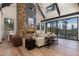 Open living area with stone fireplace, high ceilings, and access to deck with mountain views at 245 Fairways Dr, Breckenridge, CO 80424