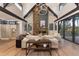 Spacious living room with a large stone fireplace and hardwood floors, large windows, and high ceilings at 245 Fairways Dr, Breckenridge, CO 80424