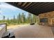 Covered patio with stone wall, fire pit, and mountain views at 245 Fairways Dr, Breckenridge, CO 80424