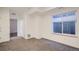 Spacious carpeted bedroom with large window and access to hallway at 1998 Foxtail Ln # B, Lafayette, CO 80026