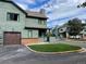 Green townhome with brown garage door and small lawn at 10330 W Jewell Ave # A, Lakewood, CO 80232