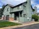 Two-story green townhome with brick base and small patio at 10330 W Jewell Ave # A, Lakewood, CO 80232
