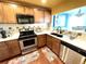 Kitchen with wood cabinets, stainless steel appliances, and a breakfast bar at 10330 W Jewell Ave # A, Lakewood, CO 80232
