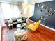 Living room with dark gray couch, yellow armchair, and wood floors at 10330 W Jewell Ave # A, Lakewood, CO 80232