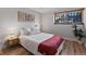 Cozy bedroom with wood floors, neutral bedding, and lovely artwork at 1260 York St # 105, Denver, CO 80206