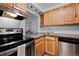 Modern kitchen with wood cabinets, stainless steel appliances, and tile backsplash at 1260 York St # 105, Denver, CO 80206