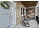 Cozy covered front porch with seating, wreath, and stone accent wall at 745 Robert St, Longmont, CO 80503